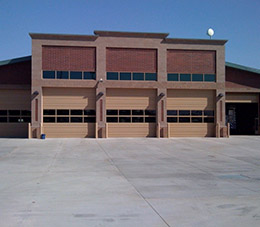 Two single car garage doors on a commercial building, ribbed model in white